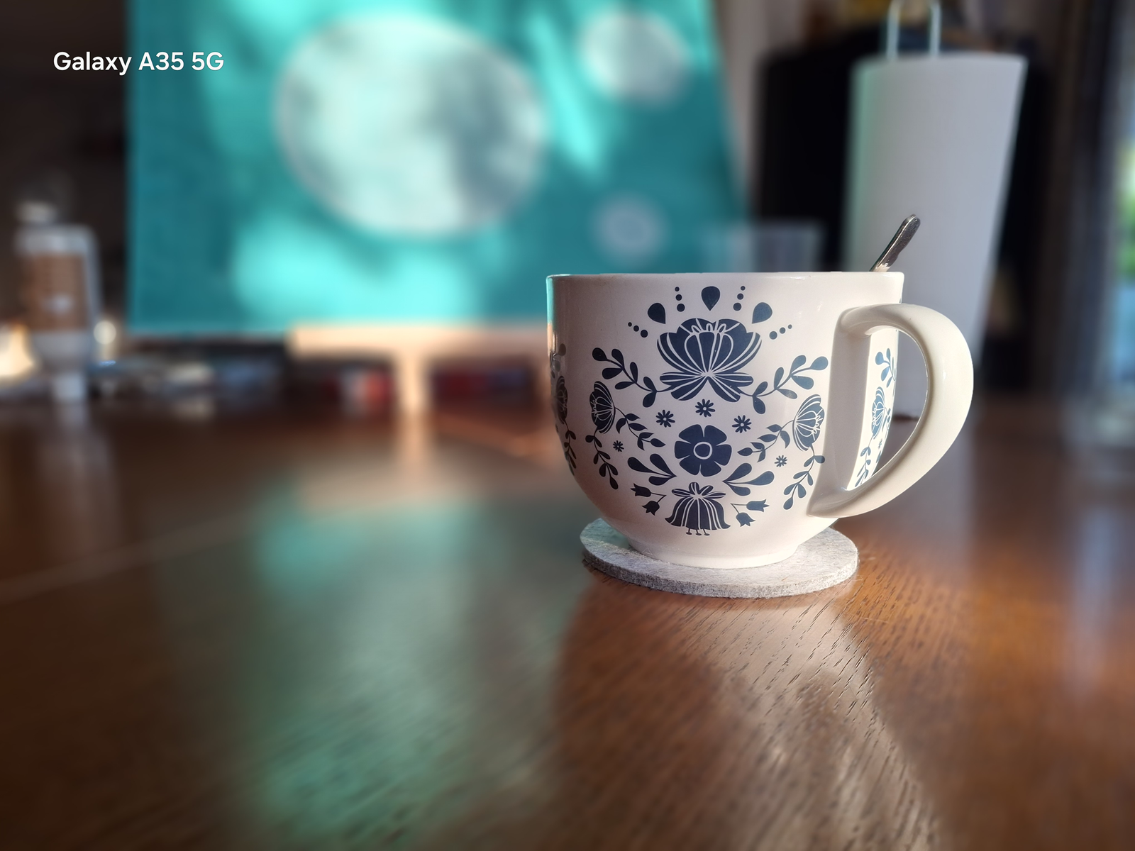 Eine Tasse Tee als Symbol für Ruhe und Achtsamkeit vor einem Gemälde – ein Moment für einen liebevollen Gedankenstopp.