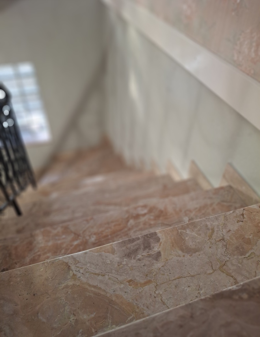 Blick von oben auf eine helle Marmortreppe mit mehreren Stufen.